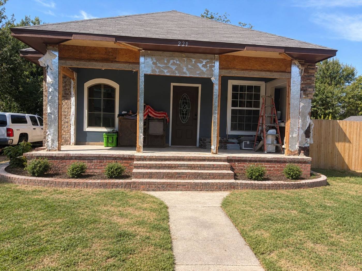After: cleared front porch with new brick planter, shrubs and fresh lawn